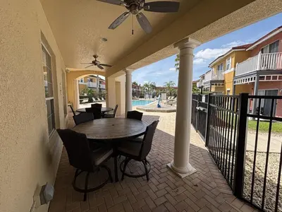 a patio with a table and chairs and a pool at Relax and unwind in this Cozy Home Away from Home in Kissimmee