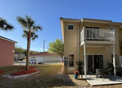 a house with a balcony and a palm tree at Relax and unwind in this Cozy Home Away from Home in Kissimmee