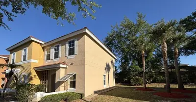 a house with palm trees in front of it at Relax and unwind in this Cozy Home Away from Home in Kissimmee