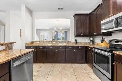 a large kitchen with wooden cabinets and appliances at Fantastic 6BR Themed Encore Home in Orlando