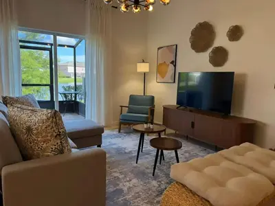 a living room with a couch and a flat screen tv at 2335 Amazing 5BD Family Townhome Close to Disney in Kissimmee