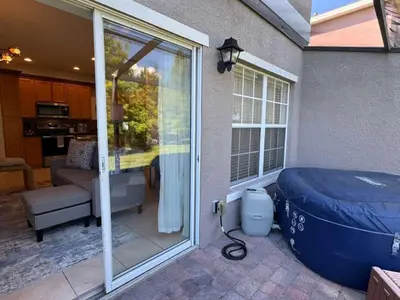 a patio with a large tub next to a sliding glass door at 2335 Amazing 5BD Family Townhome Close to Disney in Kissimmee