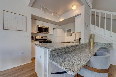 a kitchen with white cabinets and a counter top at Charming and Cozy Townhome Near Disney in Kissimmee