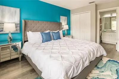 a bedroom with a large bed and a blue wall at The Minions Mansion 6br Resort Pool Home By Disney in Kissimmee
