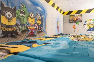 a bedroom with a bed with a painting on the wall at The Minions Mansion 6br Resort Pool Home By Disney in Kissimmee