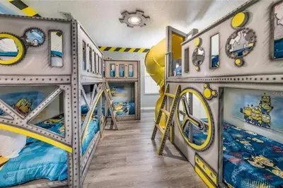 a room with two bunk beds and a slide at The Minions Mansion 6br Resort Pool Home By Disney in Kissimmee