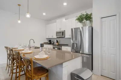 a kitchen with a table with chairs and a refrigerator at 2645 Casa Luxuosa com Piscina Privativa perto da Disney in Kissimmee