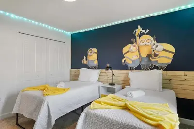 two beds in a room with a wall with minions on it at 2645 Casa Luxuosa com Piscina Privativa perto da Disney in Kissimmee