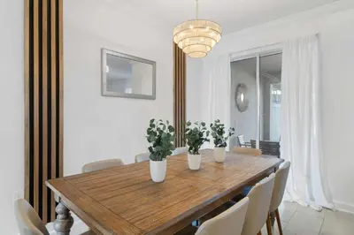 a dining room with a wooden table with plants on it at 2645 Casa Luxuosa com Piscina Privativa perto da Disney in Kissimmee