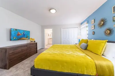 a bedroom with a yellow bed and a blue wall at Casa 4 Quartos com Piscina Privativa Storey Lake in Kissimmee