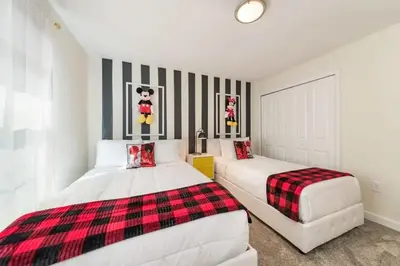 two beds in a white room with red and black stripes at Casa 4 Quartos com Piscina Privativa Storey Lake in Kissimmee