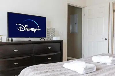 a bedroom with a television on top of a dresser at 4BR Family Townhouse Steps to Disney in Kissimmee