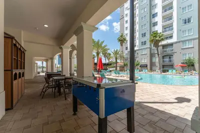 a ping pong table in the middle of a patio with a pool at King Queen Spacious Studio Near Universal in Orlando