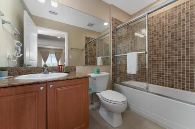 a bathroom with a toilet and a sink and a shower at Combined units 2 Kitchens Sleeps 6 in Orlando
