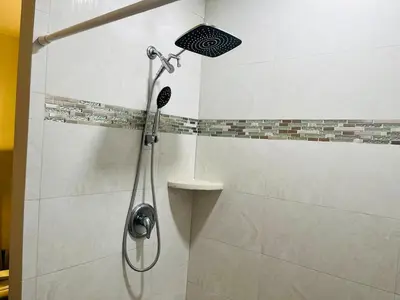 a shower with a shower head in a bathroom at Beautiful Guest Suite with Private Driveway and Entrance in Orlando