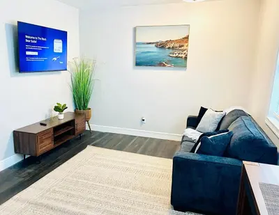 a living room with a blue couch and a tv at Beautiful Guest Suite with Private Driveway and Entrance in Orlando