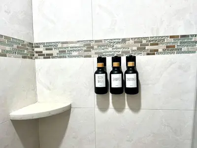 three bottles of wine sitting on a wall in a bathroom at Beautiful Guest Suite with Private Driveway and Entrance in Orlando
