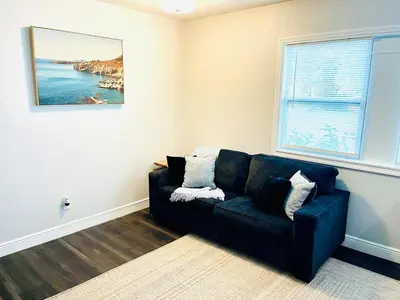 a living room with a blue couch and a window at Beautiful Guest Suite with Private Driveway and Entrance in Orlando