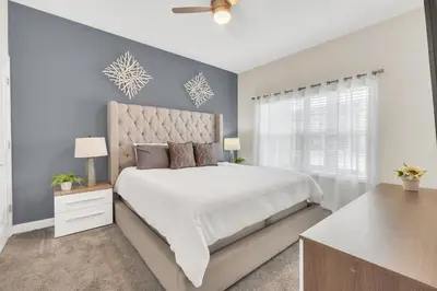 a bedroom with a large white bed and a window at Storey Lake Escape with Pool in Kissimmee