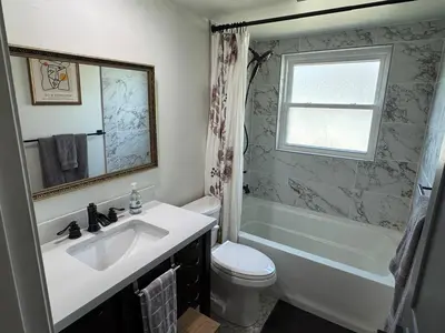 a bathroom with a sink and a tub and a toilet at Family Fun 3-bedroom house with gym, games, toys, outdoor hangout and coffee in Orlando