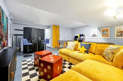 a living room with a yellow couch and a table at Whimsical Mouse Manor in Orlando