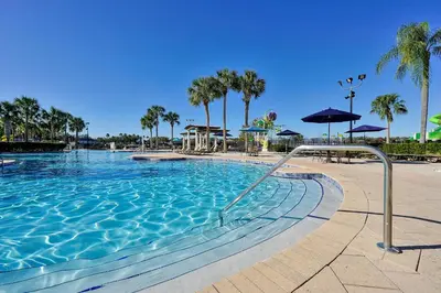 a swimming pool at a resort with palm trees at Whimsical Mouse Manor in Orlando