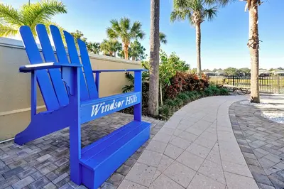 a blue chair sitting next to a walkway at Whimsical Mouse Manor in Orlando