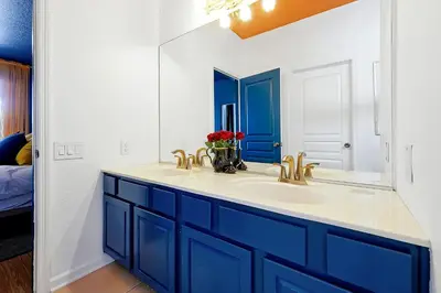 a bathroom with a blue sink and a mirror at Whimsical Mouse Manor in Orlando