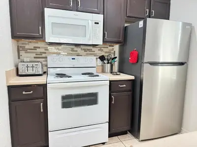 a kitchen with a white stove and a refrigerator at 4 Bedroom 3 Bathroom Villas At SevenDwarfs 4-108 in Kissimmee