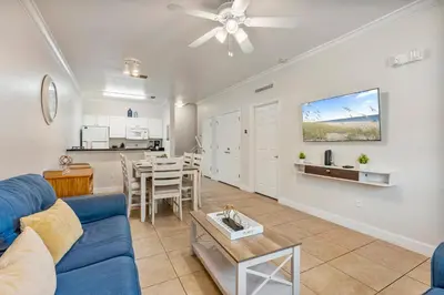 a living room with a blue couch and a kitchen at Cozy 3BDR house near Disney in Kissimmee