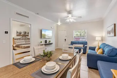 a living room with a table and a blue couch at Cozy 3BDR house near Disney in Kissimmee