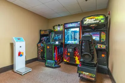 a room with three video game machines in a room at Orlando 2BR Apt Full Kitchen Near Parks in Orlando