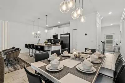 a dining room and kitchen with a table and chairs at Casa moderna com piscina privativa perto da Disney in Kissimmee