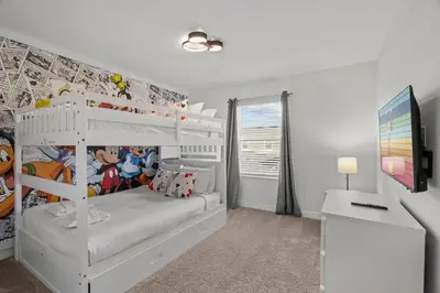 a bedroom with a white bunk bed and a tv at Casa moderna com piscina privativa perto da Disney in Kissimmee