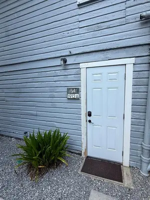a white door in front of a blue building at Cute and Cozy Apt Near Historic Downtown Sanford in Sanford