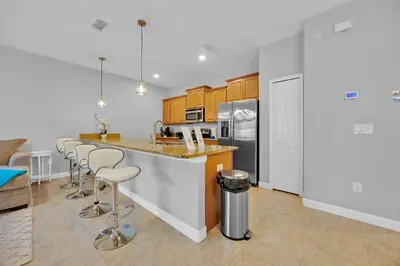 a kitchen with a counter and bar with stools at Disney Themed Home l Private Pool l Lazy River in Kissimmee
