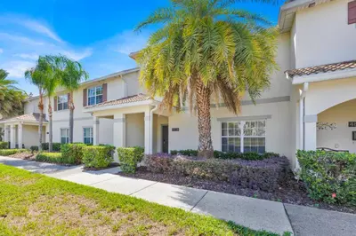 a house with palm trees and a sidewalk at Disney Themed Home l Private Pool l Lazy River in Kissimmee
