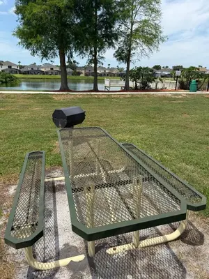 a green park bench with a light on top of it at Kissimmee Vacation Beautiful Home in Kissimmee
