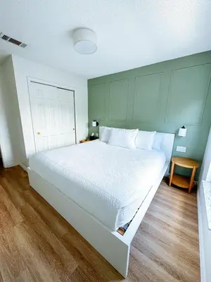 a large white bed in a bedroom with a wooden floor at Kissimmee Vacation Beautiful Home in Kissimmee