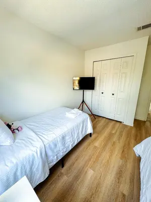 a bedroom with a bed and a flat screen tv at Kissimmee Vacation Beautiful Home in Kissimmee
