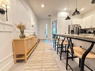 a kitchen with a bar with chairs and a counter top at Magical 4BR Escape - Pet-Friendly, 9 Min to Disney in Orlando