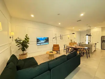 a living room with a blue couch and a table at Magical 4BR Escape - Pet-Friendly, 9 Min to Disney in Orlando