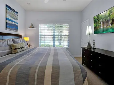 a bedroom with a large bed and a large window at Adorable Townhouse Completely Remodeled,3002Pp in Kissimmee