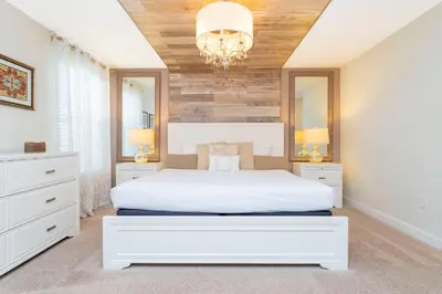 a bedroom with a white bed and a chandelier at Rare!Lake Front Pool-Spa, Close To Clubhouse-1691C in Kissimmee