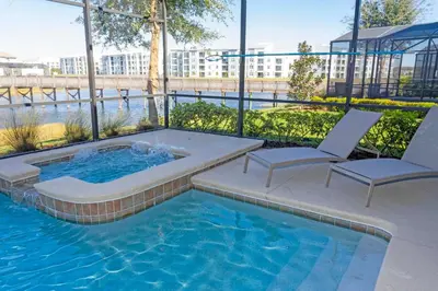 a pool with two chairs and a hot tub at Rare!Lake Front Pool-Spa, Close To Clubhouse-1691C in Kissimmee