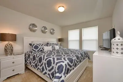 a bedroom with a bed with a black and white comforter at Charming Waterfront Townhome - 1954Cy in Kissimmee