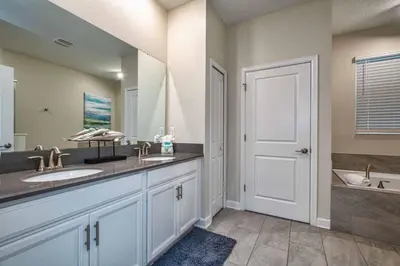 a bathroom with two sinks and a tub at Luxury Home Close To Disney, Bbq, Spa-1690St in Kissimmee