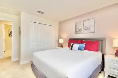 a bedroom with a large bed with red and blue pillows at Family Retreat W-Splashpool-1637St in Kissimmee