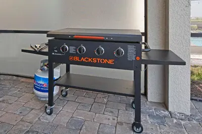 a barbecue grill on a cart on a patio at Storey Lake 8 Bed Lake Front Pool Spa - 1684Str in Kissimmee