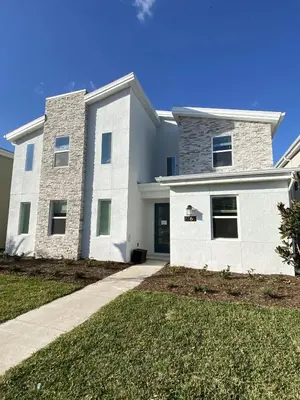 a large white house with a driveway at Beautiful Brand New Waterfront Retreat!1689St in Kissimmee
